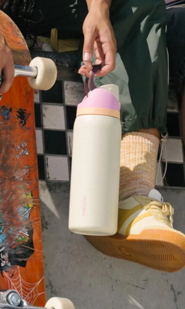Termo Owala FreeSip color Day Break junto a una patineta