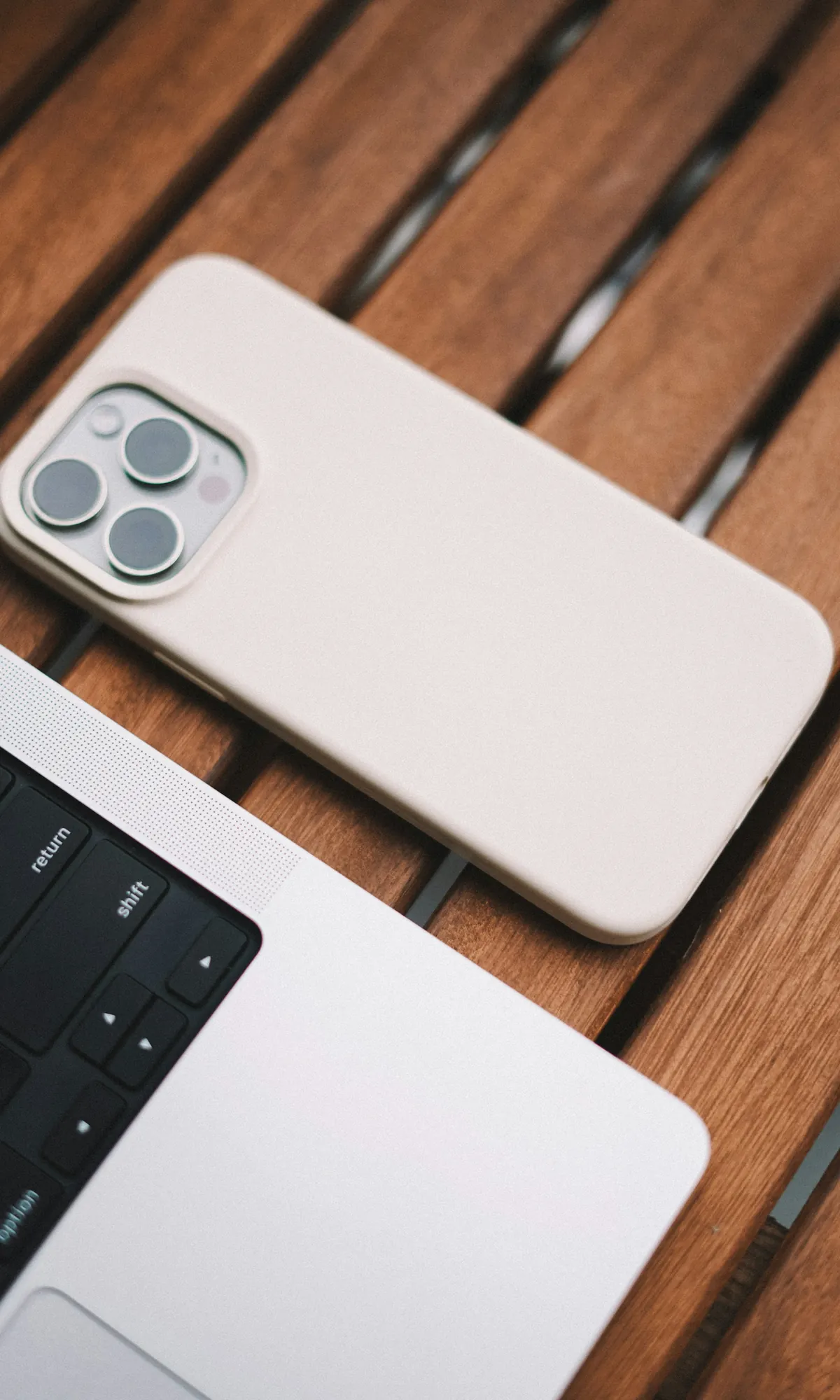 iPhone con funda de silicona rosa claro sobre una laptop